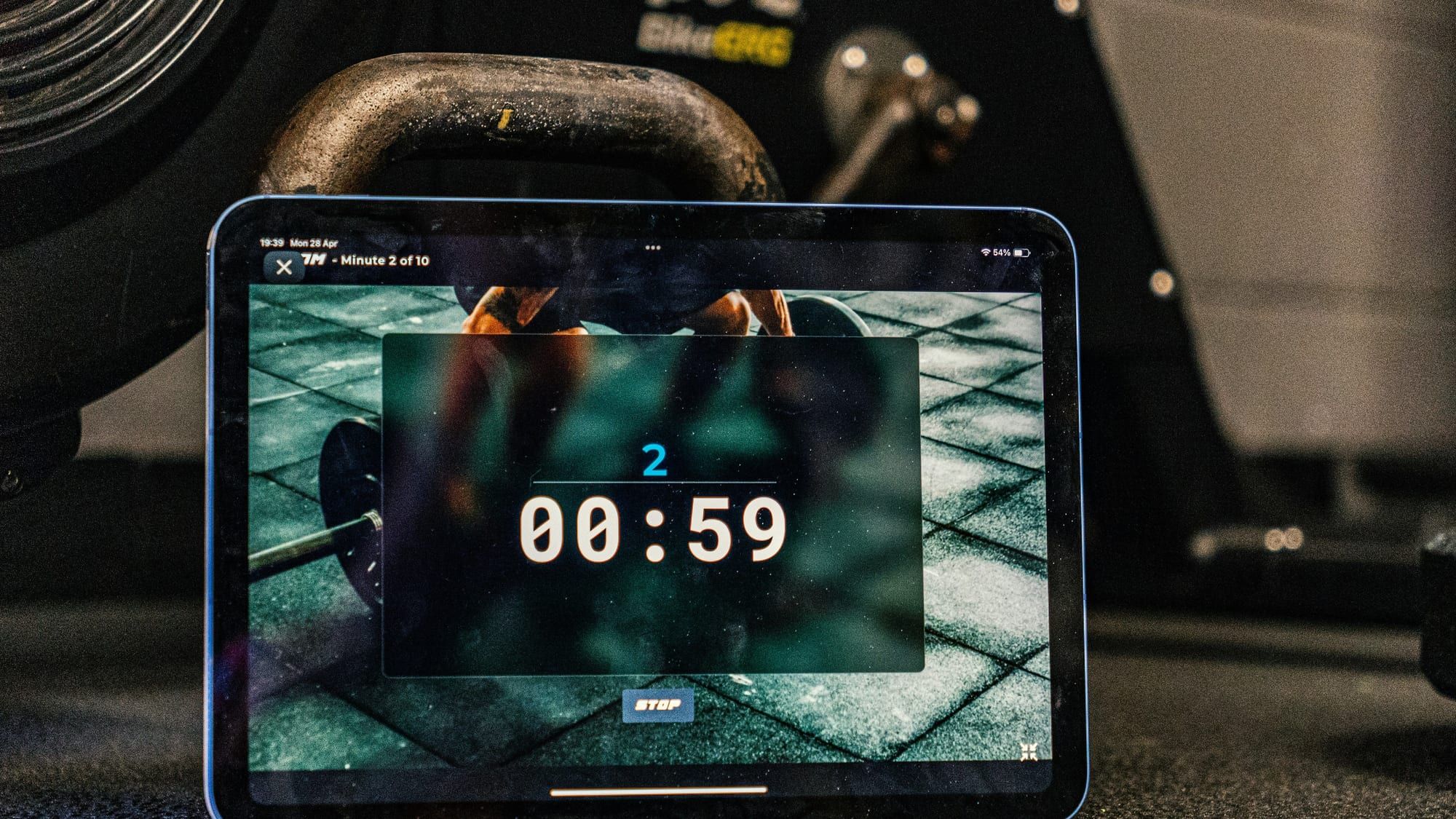 Nettbrett med nedtelling fra en treningsapp, montert foran en sykkelrulle